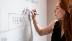 Woman writing on a white board